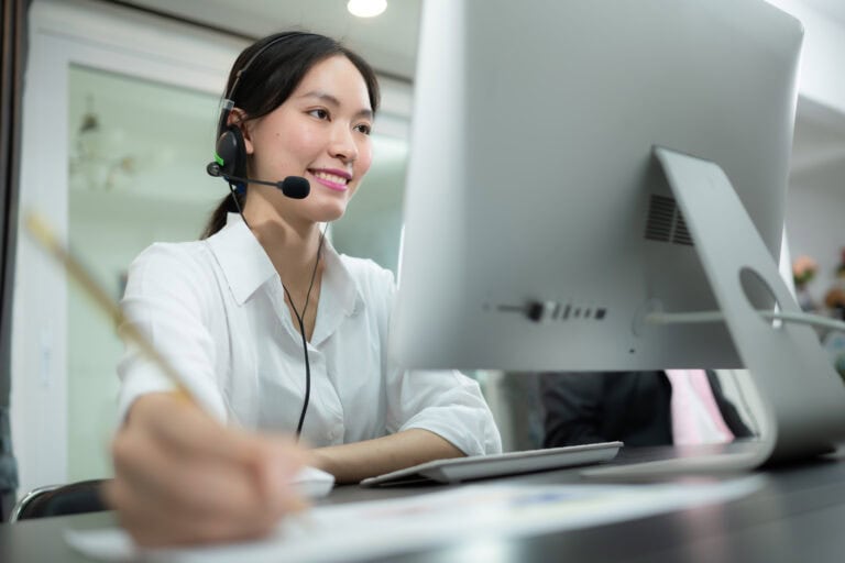 Portrait of business people wearing headset working actively in office. Call center, telemarketing, customer support agent provide service on telephone video conference call.